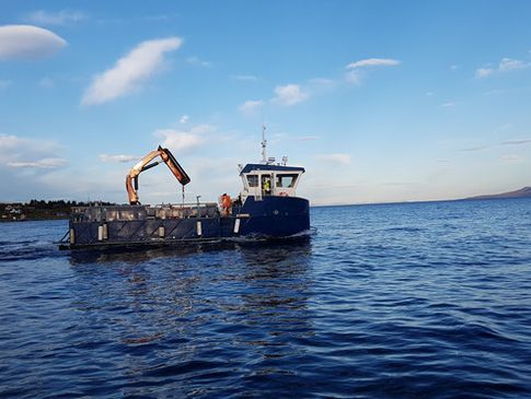 Blå båt med gul kran på sjøen